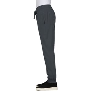 A grey jogger pant with an elastic waistband and pockets, featuring a logo on the leg.