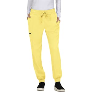 A pair of yellow jogger pants with a drawstring waistband and side pockets, featuring a logo on the leg.