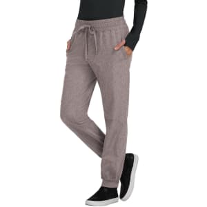 A pair of light brown jogger pants with a drawstring waist and side pockets, worn with a black long-sleeve top.
