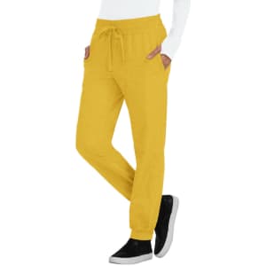 A pair of yellow jogger pants with pockets and a drawstring waist, worn with black shoes.