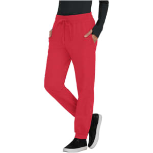 A red pair of jogger pants with pockets and a drawstring waist, styled with a black long-sleeve top and black shoes.