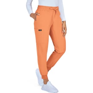 An orange jogger pant with a drawstring waist and side pockets, styled with a white long-sleeve top and white shoes.