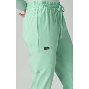 A pair of mint green jogger pants with an elastic waistband and side pockets, featuring a logo.