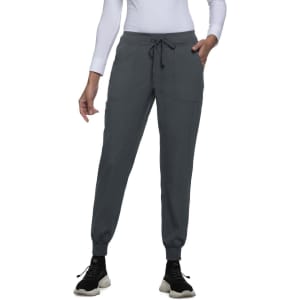 A pair of grey joggers with a drawstring waist and ankle cuffs, displayed on a model wearing a long-sleeve top and sneakers.