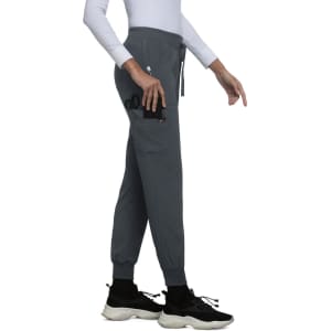 A pair of grey jogger pants with pockets and adjustable waistband, modelled by a person. Features a logo.
