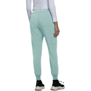 A pair of mint green jogger pants with elastic cuffs and back pockets, worn with a long-sleeved white top.