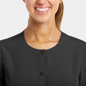A round neck jacket in dark grey with snap buttons, featuring a close-up of the collar and neckline.