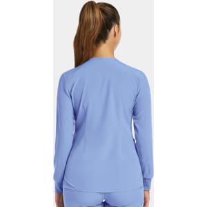 A women's round neck snap jacket in light blue, featuring a fitted design and long sleeves. It has a logo on the back.