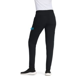 Fitted black jogger pants with side pockets and a logo on the thigh, worn with a white top and sneakers.
