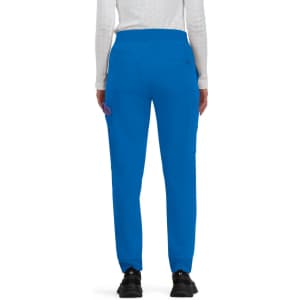 Bright blue jogger pants with a relaxed fit, featuring side pockets and an elastic waistband, worn by a person from behind.