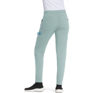 A pair of light green joggers with pockets, featuring an elastic waistband and a logo on the side.