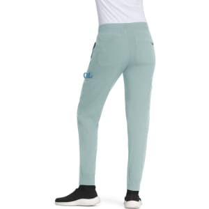 A pair of light green jogger pants with pockets, worn with a white top and black shoes. The pants feature a subtle logo.