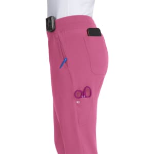 Pink jogger pants featuring a side pocket with a phone and a small pocket holding scissors and a pen.