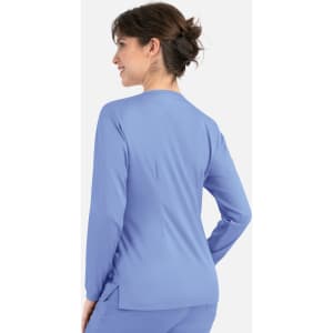 A woman wearing a light blue round neck snap jacket, viewed from the back. The jacket has a simple design and includes a logo.
