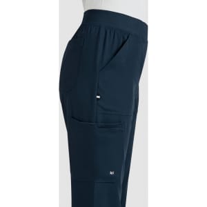 A side view of navy boot cut pants featuring pockets and a logo on the leg.