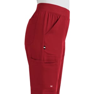 A pair of red boot cut pants with pockets displayed from the side, featuring a small logo.