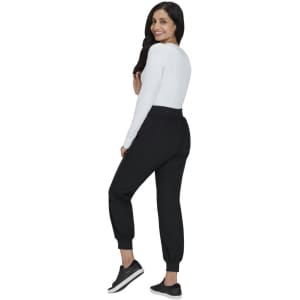 A woman in a white top and black joggers poses from the back, showcasing the Hettie Jogger style.