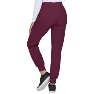 A pair of burgundy joggers with pockets and elastic cuffs, worn with a white long-sleeve top and black sneakers.