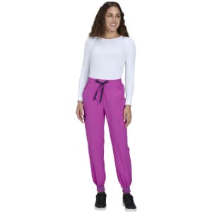 A woman in a white long-sleeve top wears vibrant pink joggers with a black drawstring and elastic cuffs.