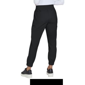 Black jogger pants featuring elastic cuffs and pockets, showcased from the back with a model wearing shoes.