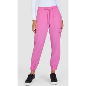 A pair of pink jogger pants featuring elastic cuffs and side pockets, styled with a white long-sleeve top.