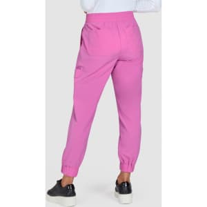 A pair of pink jogger pants with elastic cuffs, featuring pockets and a relaxed fit. The model is wearing black shoes.