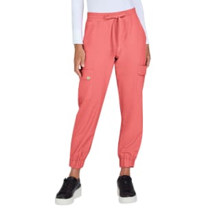 A pair of coral jogger pants with side pockets, elastic cuffs, and a drawstring waist, worn with black shoes.