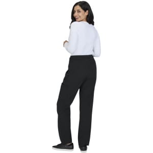 A woman wearing black wide-leg pants and a white long-sleeve top, facing away from the camera.