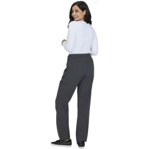 A woman wearing grey wide-leg pants and a white long-sleeve top, facing away from the camera.