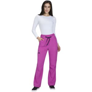 A woman wearing bright pink wide leg pants with pockets, paired with a white long-sleeve top.