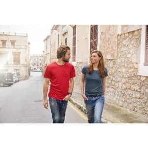 A red men's t-shirt and a blue women's t-shirt worn by two people walking together on a street.