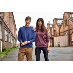 A blue and a maroon jumper worn by a man and a woman standing in an urban setting with industrial buildings.