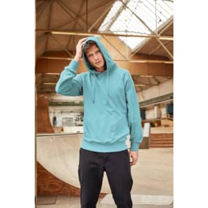 A teal men's hoodie featuring a front pocket and drawstring hood, worn by a model in an indoor skatepark.