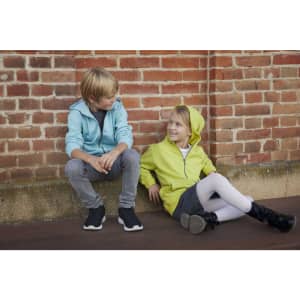 A blue zip hoodie and a lime green zip hoodie worn by a boy and a girl seated against a brick wall.