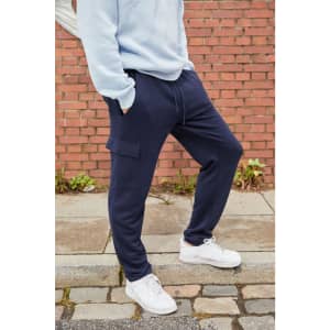 Navy blue men's lounge pants with side pockets, styled with a light blue sweatshirt and white sneakers.