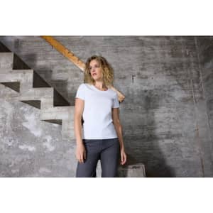 A white ladies T-shirt with a fitted design, displayed against a textured concrete wall and staircase.