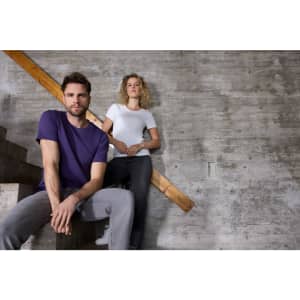 A purple T-shirt and a white T-shirt displayed by a man sitting on stairs and a woman standing nearby, both in casual attire.