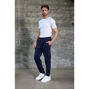 A model wearing navy interlock pants with pockets, paired with a white t-shirt and white sneakers.