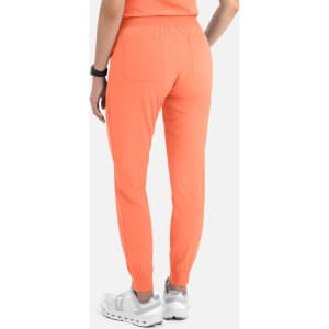 A pair of women's joggers in bright orange, featuring a tapered design and elasticated cuffs. The joggers have a branding logo.