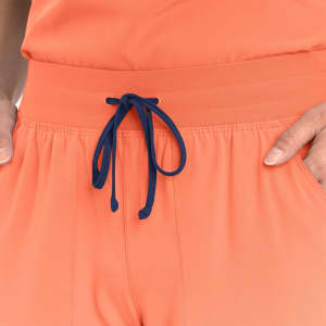 An orange jogger with a navy blue drawstring, featuring an elastic waistband and side pockets.