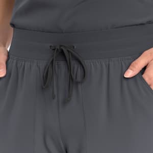 A grey women's jogger featuring a drawstring waist and a smooth fabric texture. It has a logo visible on the waistband.