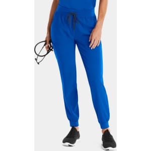 Bright blue women's jogger pants with cuffed hems, an elastic waistband, and pockets, paired with black athletic shoes.
