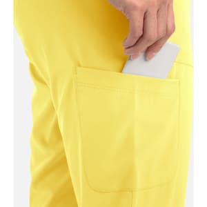 A pair of yellow joggers featuring a pocket with a hand placing a phone inside.