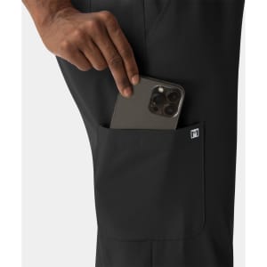 Black women's skinny pull-on pant with a pocket, showing a hand placing a phone inside. Features a logo.