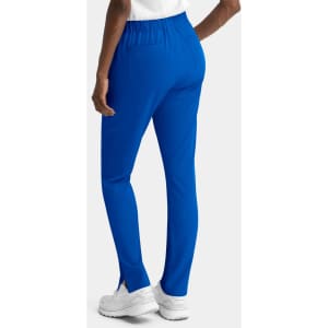 A pair of women's skinny pull-on pants in vibrant blue, featuring a stretchy waistband and side slits at the hem.