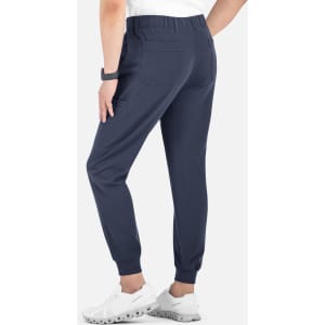 A pair of navy joggers with a full elastic waistband and back pockets, worn with white sneakers.