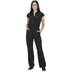 A black jumpsuit featuring short sleeves and zippered pockets, modelled by a smiling woman. It has a logo.