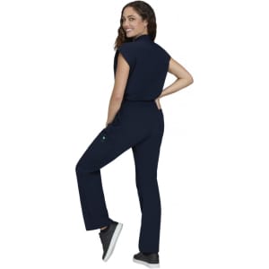 A navy blue Anja Jumpsuit worn by a model, featuring a fitted design and a pocket, displayed from the side.