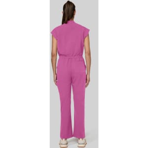 A pink jumpsuit with short sleeves and a relaxed fit, featuring a belt around the waist and flared legs.