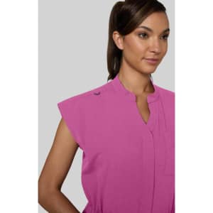 A pink jumpsuit with short sleeves and a high collar, featuring a logo on the shoulder.